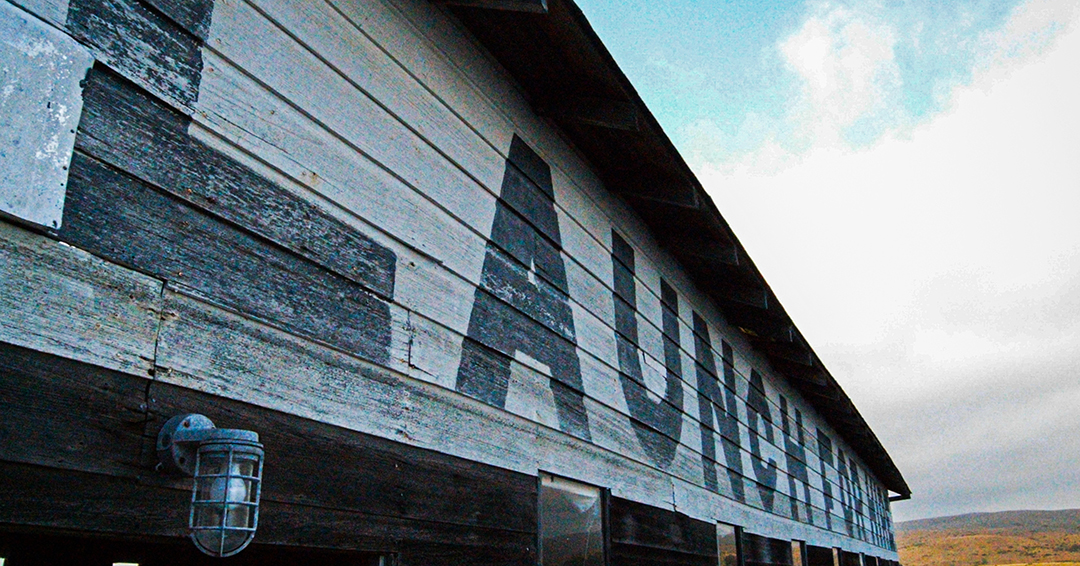 image of a boat house on Tomales Bay, CA, with the words "LAUNCH FOR HIRE" in large, fading letters painted on its side